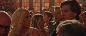 Movie still from “Isn't It Romantic” (2019), directed by Todd Strauss-Schulson – A group of people standing around each other in a room; Close Up shot, Over the shoulder angle