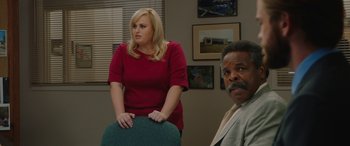 Movie still from “Isn't It Romantic” (2019), directed by Todd Strauss-Schulson – A woman standing next to a man in a room; Medium shot, Over the shoulder angle