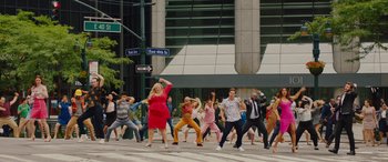 Movie still from “Isn't It Romantic” (2019), directed by Todd Strauss-Schulson – A group of people dancing on the sidewalk; Extreme Wide shot, High angle