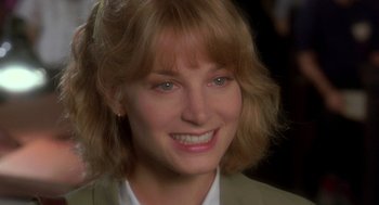 Movie still from “It Could Happen to You” (1994), directed by Andrew Bergman – A person smiling for the camera; Close Up shot, Over the shoulder angle