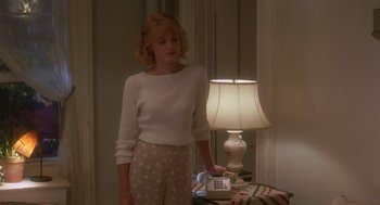 Movie still from “It Could Happen to You” (1994), directed by Andrew Bergman – A woman standing in front of a table with a lamp; Medium shot, Low angle