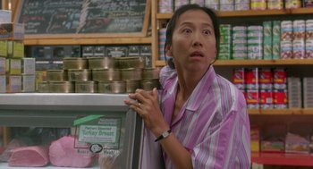 Movie still from “It Could Happen to You” (1994), directed by Andrew Bergman – A woman standing in front of a display case; Close Up shot, Over the shoulder angle