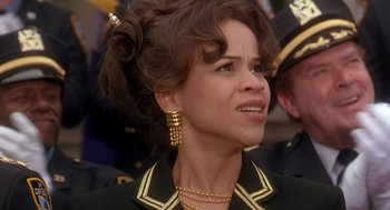 Movie still from “It Could Happen to You” (1994), directed by Andrew Bergman – A person wearing a suit and tie; Close Up shot, Over the shoulder angle