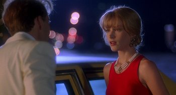 Movie still from “It Could Happen to You” (1994), directed by Andrew Bergman – A woman in a red dress talking to a man in a car; Close Up shot, Over the shoulder angle