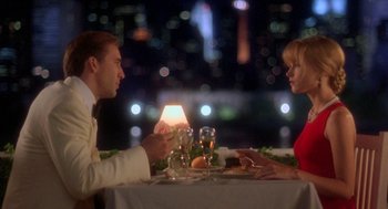 Movie still from “It Could Happen to You” (1994), directed by Andrew Bergman – A man and a woman sitting at a dinner table; Medium shot, Over the shoulder angle
