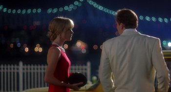 Movie still from “It Could Happen to You” (1994), directed by Andrew Bergman – A man and a woman standing next to each other; Medium shot, Over the shoulder angle