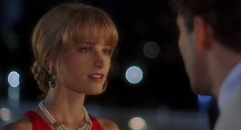 Movie still from “It Could Happen to You” (1994), directed by Andrew Bergman – A woman in a red dress talking to a man in a red suit; Close Up shot, Over the shoulder angle