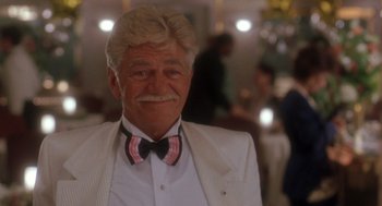 Movie still from “It Could Happen to You” (1994), directed by Andrew Bergman – An older man wearing a white suit and a bow tie; Close Up shot, Low angle