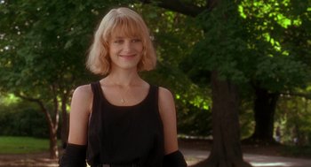 Movie still from “It Could Happen to You” (1994), directed by Andrew Bergman – A woman with blonde hair and a black top; Medium shot, Low angle