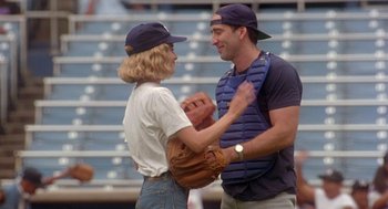 Movie still from “It Could Happen to You” (1994), directed by Andrew Bergman – A man and a woman wearing catchers mitts; Medium shot, Over the shoulder angle