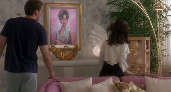 Movie still from “It Could Happen to You” (1994), directed by Andrew Bergman – Two people standing in front of a painting of a woman; Medium shot, Over the shoulder angle