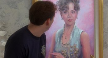 Movie still from “It Could Happen to You” (1994), directed by Andrew Bergman – A man standing next to a painting of a woman; Close Up shot, Over the shoulder angle