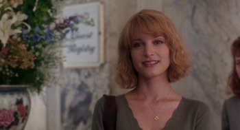 Movie still from “It Could Happen to You” (1994), directed by Andrew Bergman – A person wearing a green shirt; Close Up shot, Over the shoulder angle