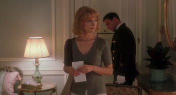 Movie still from “It Could Happen to You” (1994), directed by Andrew Bergman – A woman standing next to a man in a room; Medium shot, Over the shoulder angle