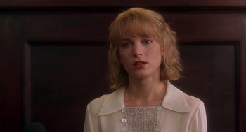 Movie still from “It Could Happen to You” (1994), directed by Andrew Bergman – A woman with blonde hair wearing a white jacket; Close Up shot, Over the shoulder angle