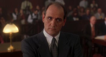 Movie still from “It Could Happen to You” (1994), directed by Andrew Bergman – A man wearing a suit and tie in front of a crowd; Close Up shot, Low angle