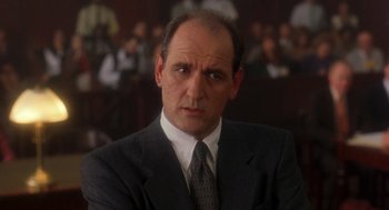 Movie still from “It Could Happen to You” (1994), directed by Andrew Bergman – A person wearing a suit and tie; Close Up shot, Low angle