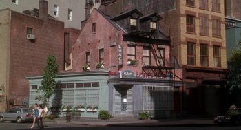 Movie still from “It Could Happen to You” (1994), directed by Andrew Bergman – A building that has a building on top of it; Wide shot, High angle