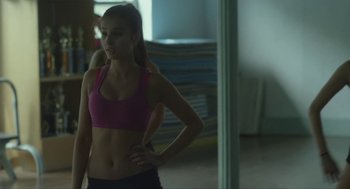 Movie still from “It Felt Like Love” (2013), directed by Eliza Hittman – A woman in a pink sports bra stands in front of a mirror; Medium shot, Over the shoulder angle