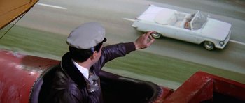 Movie still from “It Happened at the World's Fair” (1963), directed by Norman Taurog – A man in a hat and a leather jacket is holding his hand out to someone; Close Up shot, High angle