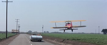 Movie still from “It Happened at the World's Fair” (1963), directed by Norman Taurog – An airplane is flying low over a grassy field; Wide shot, Low angle