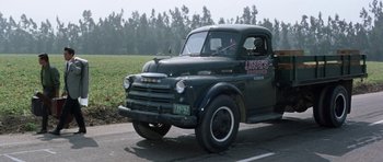 Movie still from “It Happened at the World's Fair” (1963), directed by Norman Taurog – An old truck driving down a road near a field; Wide shot, Low angle