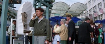 Movie still from “It Happened at the World's Fair” (1963), directed by Norman Taurog – An older man and a young girl are talking on a cell phone; Medium shot, Low angle