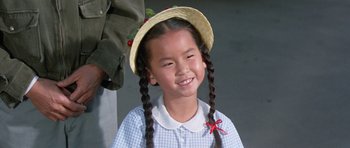 Movie still from “It Happened at the World's Fair” (1963), directed by Norman Taurog – A young girl wearing a straw hat and pigtails; Close Up shot, High angle