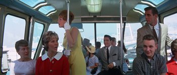 Movie still from “It Happened at the World's Fair” (1963), directed by Norman Taurog – A woman in a yellow dress and a man in a gray suit; Medium shot, Low angle