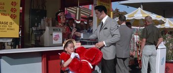Movie still from “It Happened at the World's Fair” (1963), directed by Norman Taurog – A man and a little girl with a giant teddy bear; Medium shot, High angle