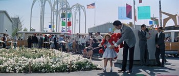 Movie still from “It Happened at the World's Fair” (1963), directed by Norman Taurog – A man and a little girl holding a red teddy bear; Extreme Wide shot, Low angle