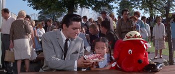 Movie still from “It Happened at the World's Fair” (1963), directed by Norman Taurog – A man and a little girl sitting at a table; Medium shot, Over the shoulder angle