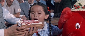 Movie still from “It Happened at the World's Fair” (1963), directed by Norman Taurog – A young girl is eating a piece of cake; Close Up shot, High angle