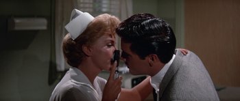 Movie still from “It Happened at the World's Fair” (1963), directed by Norman Taurog – A man and a woman in a nurse's uniform kissing each other; Close Up shot, Over the shoulder angle