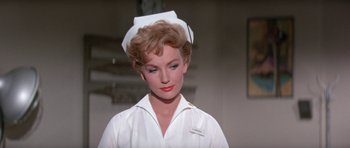 Movie still from “It Happened at the World's Fair” (1963), directed by Norman Taurog – A woman in a nurse's uniform looking to her left; Close Up shot, Low angle