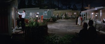 Movie still from “It Happened at the World's Fair” (1963), directed by Norman Taurog – A group of people standing in a yard at night; Extreme Wide shot, High angle