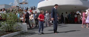 Movie still from “It Happened at the World's Fair” (1963), directed by Norman Taurog – A man in a suit and tie and a young boy in a red shirt and blue jeans; Wide shot, Low angle