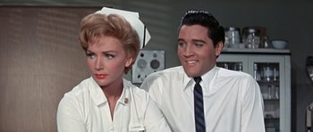 Movie still from “It Happened at the World's Fair” (1963), directed by Norman Taurog – A man and a woman wearing white shirts and ties; Medium shot, Low angle