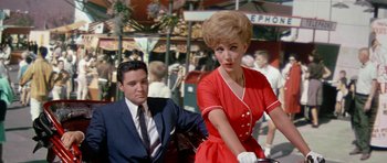 Movie still from “It Happened at the World's Fair” (1963), directed by Norman Taurog – A man and a woman in a red dress; Medium shot, Low angle