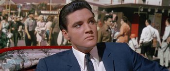 Movie still from “It Happened at the World's Fair” (1963), directed by Norman Taurog – A person wearing a suit and tie; Close Up shot, Low angle