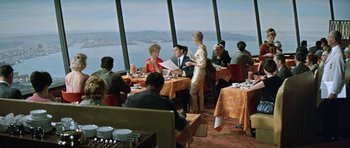 Movie still from “It Happened at the World's Fair” (1963), directed by Norman Taurog – A group of people sitting at tables in a restaurant; Wide shot, High angle