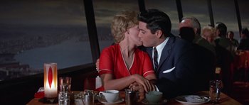 Movie still from “It Happened at the World's Fair” (1963), directed by Norman Taurog – A man and a woman kissing in front of a window; Medium shot, Low angle