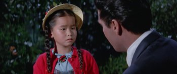 Movie still from “It Happened at the World's Fair” (1963), directed by Norman Taurog – A young girl wearing a straw hat talking to an older man; Close Up shot, Over the shoulder angle