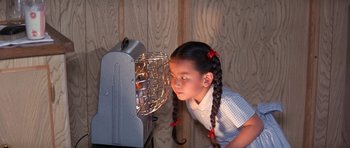 Movie still from “It Happened at the World's Fair” (1963), directed by Norman Taurog – A little girl looking into a small heater; Medium shot, High angle