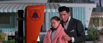 Movie still from “It Happened at the World's Fair” (1963), directed by Norman Taurog – A man and a little girl on the phone; Medium shot, Low angle