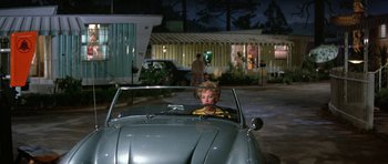 Movie still from “It Happened at the World's Fair” (1963), directed by Norman Taurog – A woman sitting in the back seat of a car; Wide shot, Over the shoulder angle