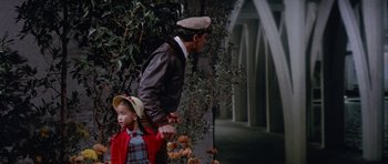 Movie still from “It Happened at the World's Fair” (1963), directed by Norman Taurog – A man and a little girl are walking together; Wide shot, High angle