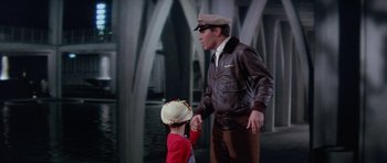 Movie still from “It Happened at the World's Fair” (1963), directed by Norman Taurog – A man in a brown jacket and a little boy in a red shirt; Medium shot, Over the shoulder angle