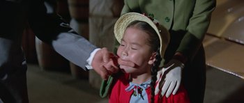 Movie still from “It Happened at the World's Fair” (1963), directed by Norman Taurog – A child being held down by a person holding a whip; Close Up shot, Over the shoulder angle