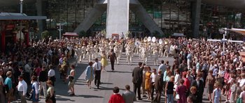 Movie still from “It Happened at the World's Fair” (1963), directed by Norman Taurog – A crowd of people walking down a street with marching band instruments; Extreme Wide shot, High angle